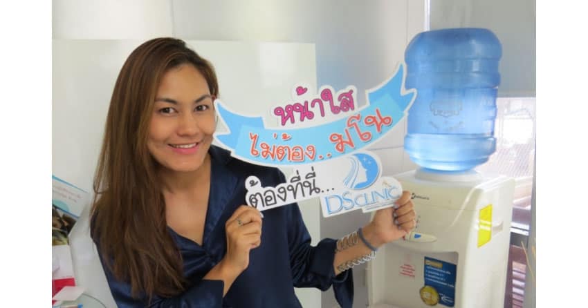 ภาพแสดงหญิงสาวถือป้ายรีวิวเติมฟิลเลอร์ที่ดูมิติและยกกระชับใบหน้าอย่างเป็นธรรมชาติ.